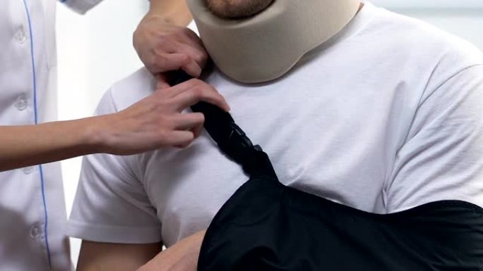 医生应用男性患者手臂吊带，创伤后治疗，车祸