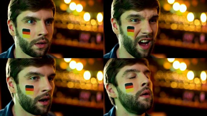 不高兴的男人脸上画着德国国旗做捂脸，球队输了比赛