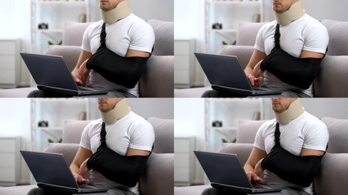 手臂吊带和颈圈的男人在家中笔记本电脑上工作，创伤治疗
