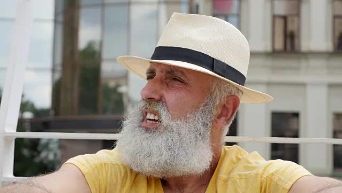 一个大胡子的老人戴着帽子扇风