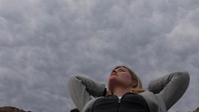 年轻女子的低空视图，上面有构图的云层