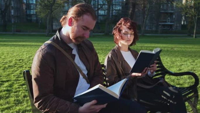 女人在公园里在男人的肩膀上读书