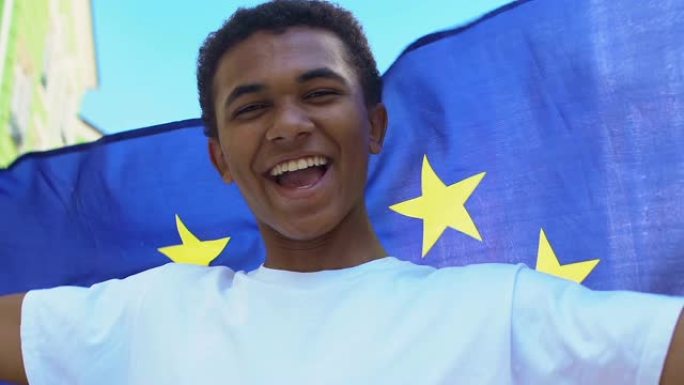 快乐的非裔美国男性挥舞着欧盟旗帜，支持政治改革