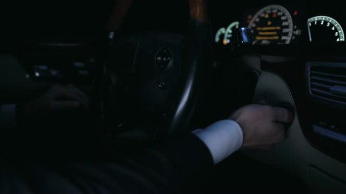 男子手动启动汽车发动机，带钥匙，控制面板上的灯，特写