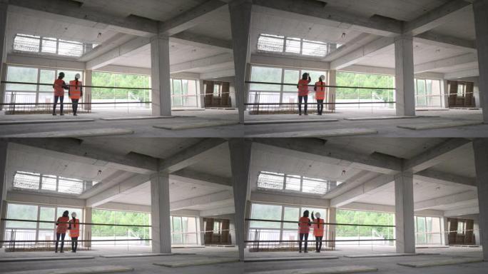 LD女服务员和女建筑师站在建筑物中，一边交谈，一边检查施工细节