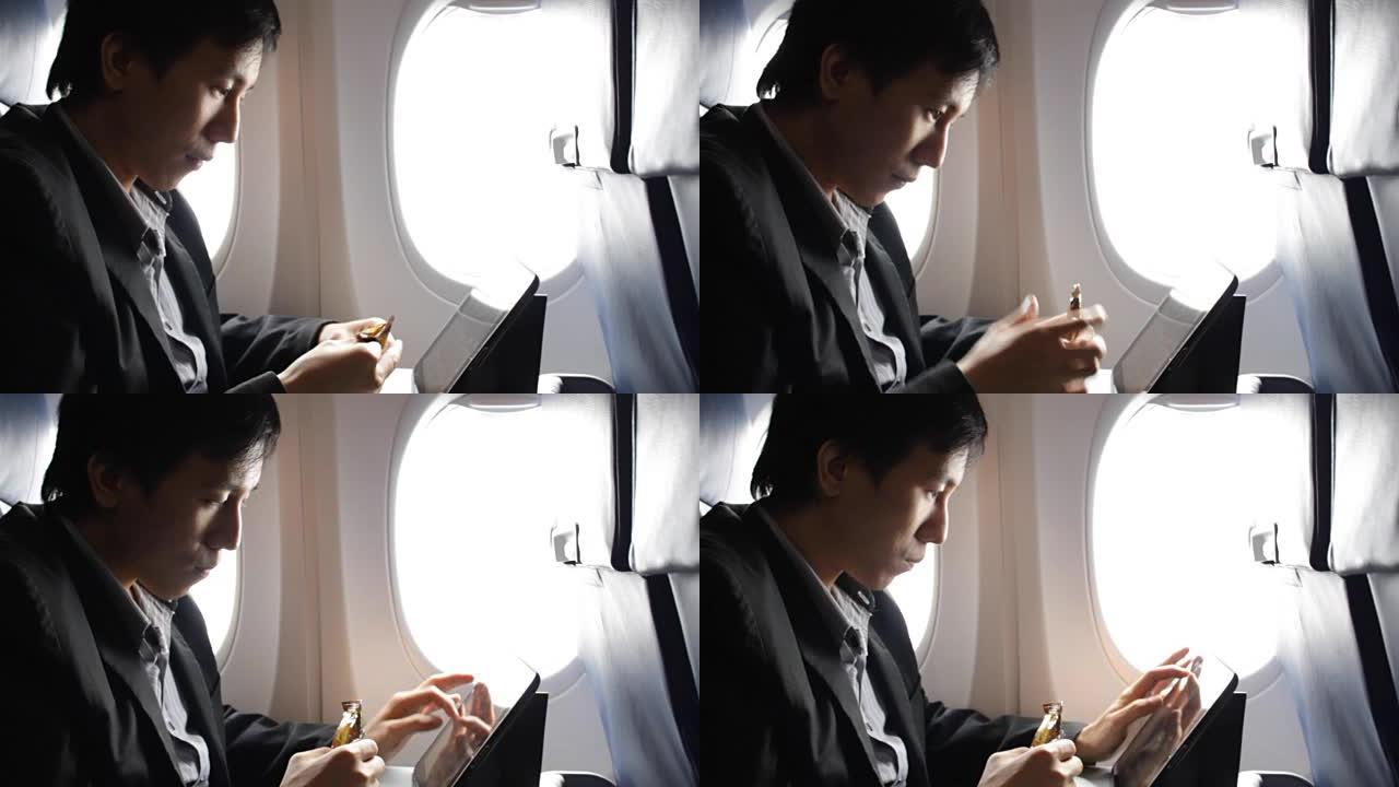 商人在吃饭时在飞机上使用平板电脑