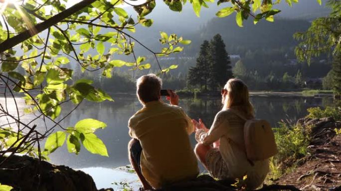 日出时，夫妇在山湖上放松