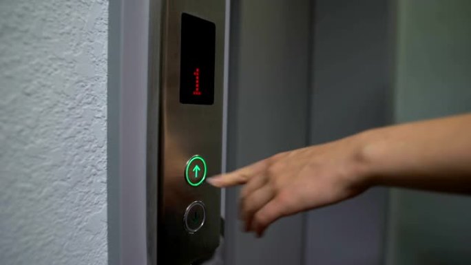 女性手指按下电梯按钮，从1层移动到上层，特写