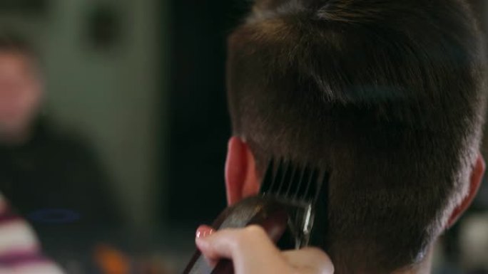 理发师工具。男性手刷电动理发推子的特写。理发师为下一个客户准备发胶机。男士清洁黑色剃须机