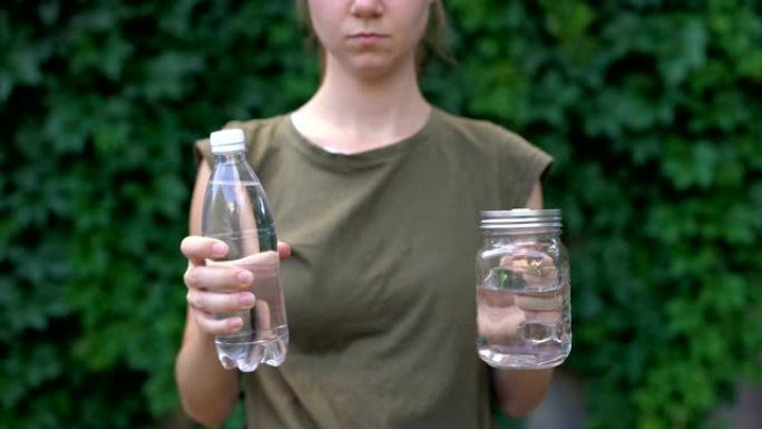 女士向相机展示玻璃杯，更喜欢塑料瓶，拯救地球