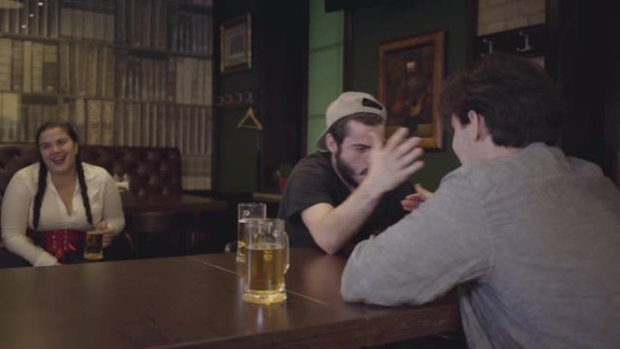 两个男人坐在酒吧的桌子旁，进行手臂摔跤。