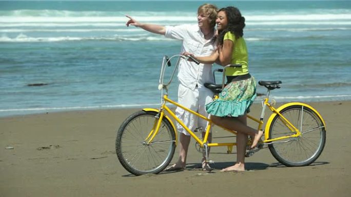 夫妇在海滩上骑着双人自行车
