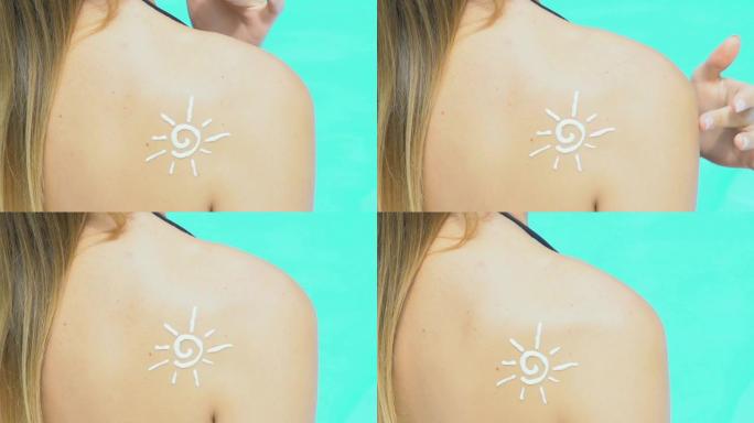 太阳形状的防晒霜在女孩身上的特写镜头，在游泳池附近晒日光浴