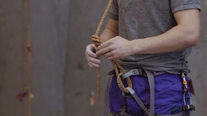 男子解开攀岩绳的结
