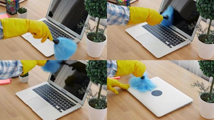 戴黄色手套的女人用蓝色刷子清洁笔记本电脑上的灰尘