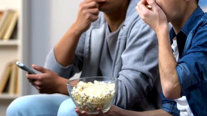 两男朋友在电视前吃爆米花看剧集插曲