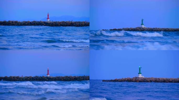 带渔民的石头码头，发光的红色和绿色灯塔