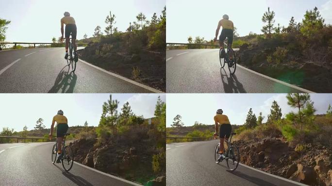 追踪一名男骑自行车者爬上山路的视频镜头。在阳光明媚的日子里，男子在丘陵公路上进行自行车训练。