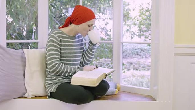 年轻的女性癌症患者拿着圣经