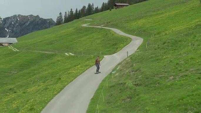 年轻成年男性滑板偏远的高山公路，可以看到山景