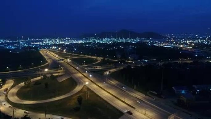 黄昏时高速公路交通和炼油厂的鸟瞰图