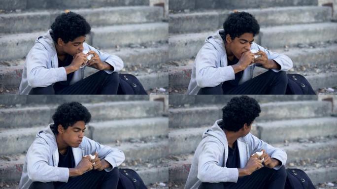 饥饿的美国黑人男孩在四处张望面包，街头生活方式