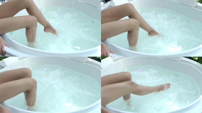 4k慢动作女性的腿沐浴在漩涡浴缸中，水上水疗腿适合热爱健康的女性。