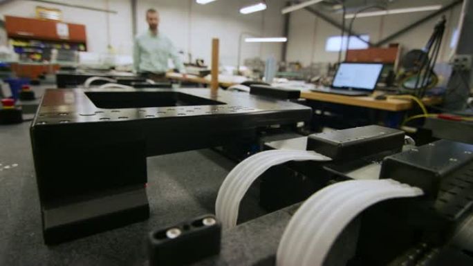 一名高加索人在制造工厂中充当平面空气轴承系统的移动和测量