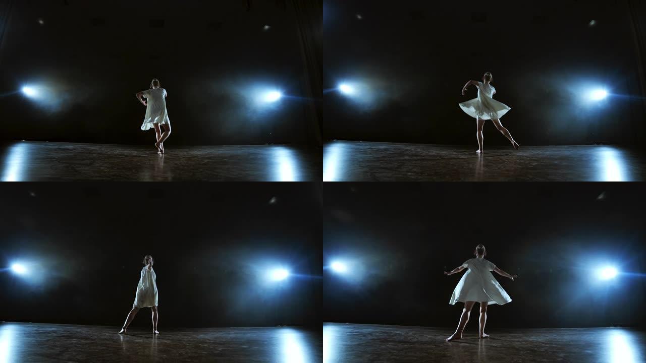 现代芭蕾舞演员的音乐独奏表演中的动态场景。在舞台上慢动作的聚光灯下跳舞。舞蹈音乐表演。月光下的戏剧性