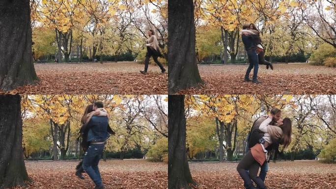 幸福的情侣在秋季公园相遇，并从快乐中旋转出来。