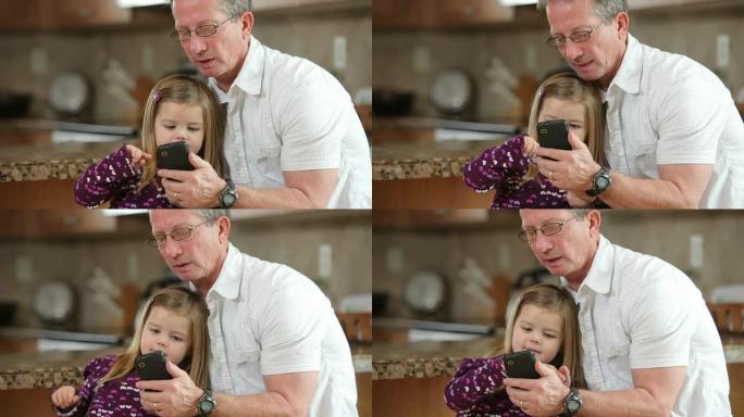 年轻女孩和祖父一起使用手机