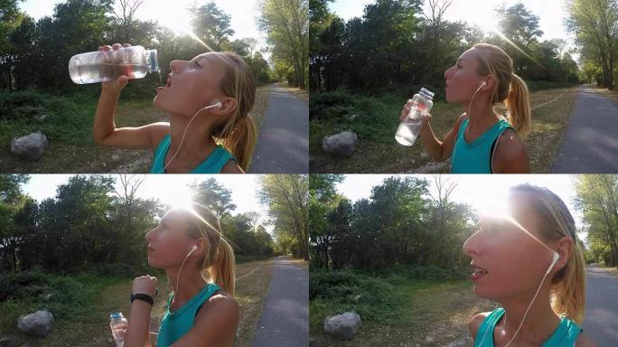 美丽而运动的年轻女子在户外慢跑后喝水