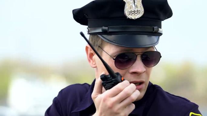 一名男性巡警通过无线电，传递有关罪犯的信息