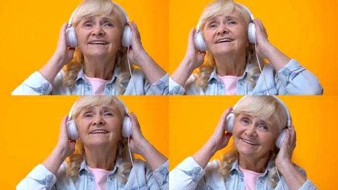 戴着白色耳机的老年妇女听音乐，享受最喜欢的旋律