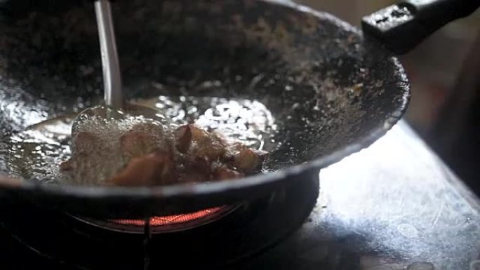 在磨损的锅中油炸的猪肉牛排