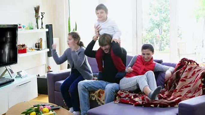 幸福的家庭在家里看电视和聊天