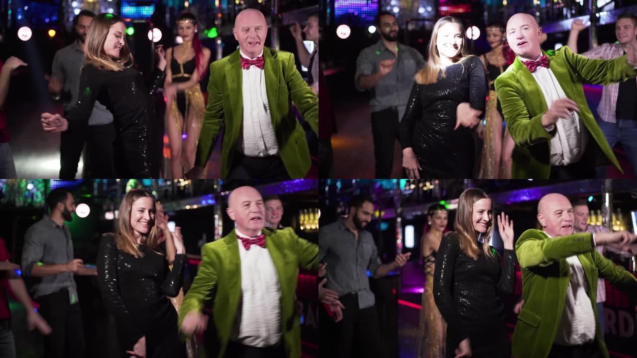 快乐的白人老人和年轻女子在夜总会跳舞。不同年龄的积极人士晚上在迪斯科舞厅休息。有趣，快乐，生活方式。