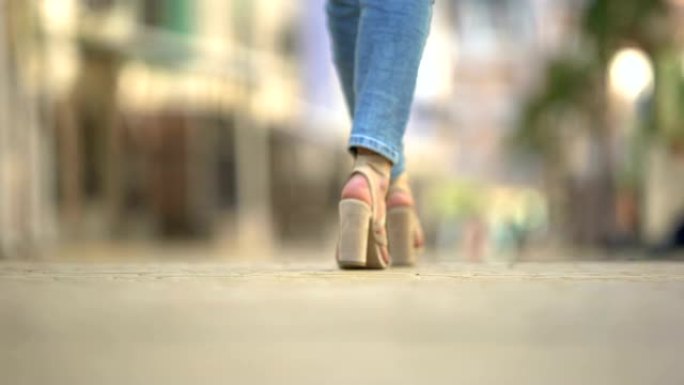穿着时尚高跟皮凉鞋的时尚女性走在街上