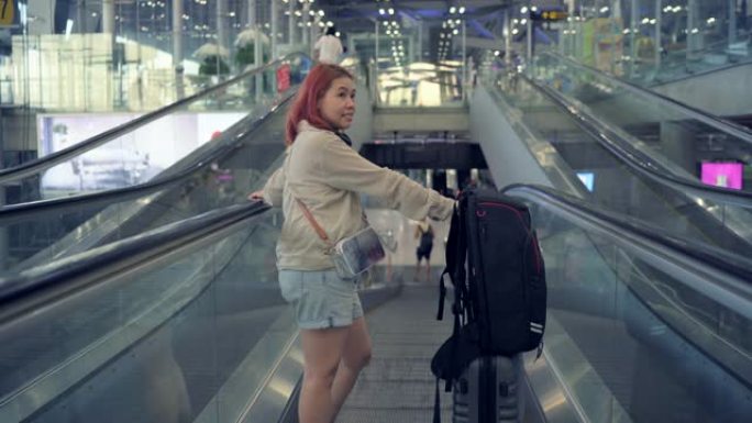 4k镜头旅客拖着行李，朝机场的自动扶梯走去