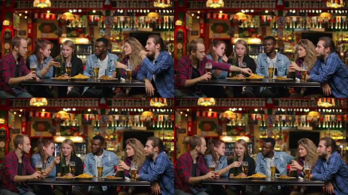 非裔美国人和朋友在酒吧喝啤酒，和朋友一起吃薯条
