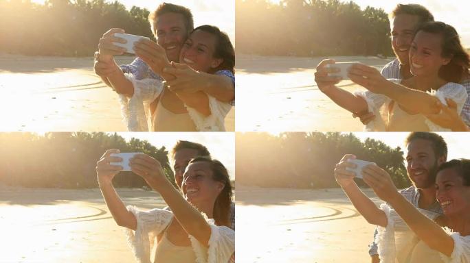 日落时海滩上的快乐夫妇自拍肖像