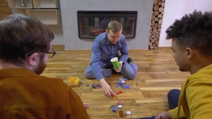 男性在地板上滚动骰子，摇动杯子，游戏娱乐，组合