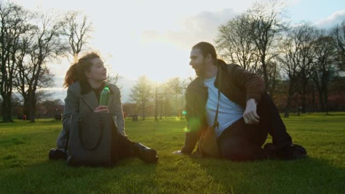 坐在公园里大笑的男人和女人
