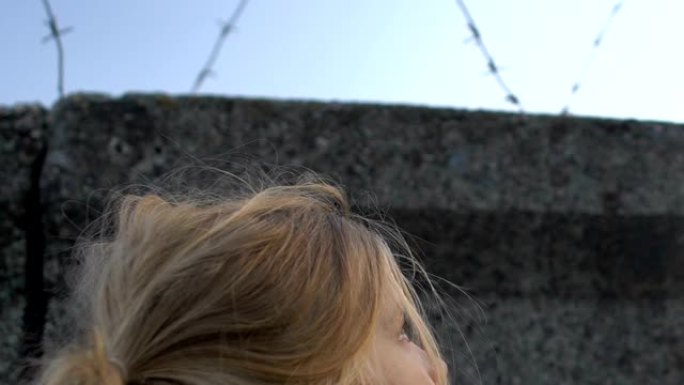 小女孩用理发店的电线看着墙，梦见自由，难民