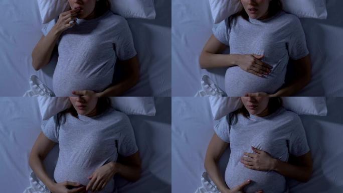 孕妇抱着肚子，躺在床上睡觉，姿势不舒服