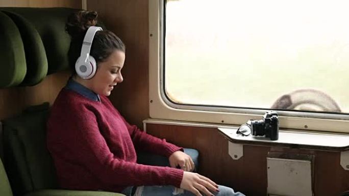 穿着休闲的女人在地铁里听音乐