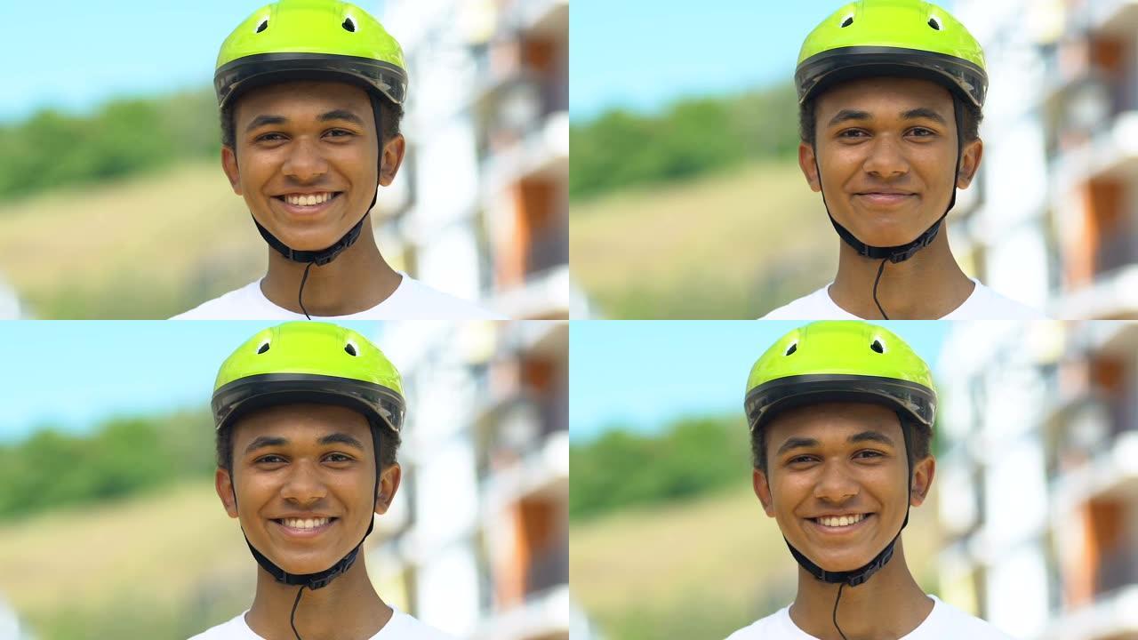 戴着自行车头盔的少年男孩对着镜头微笑，骑自行车的风险，道路安全