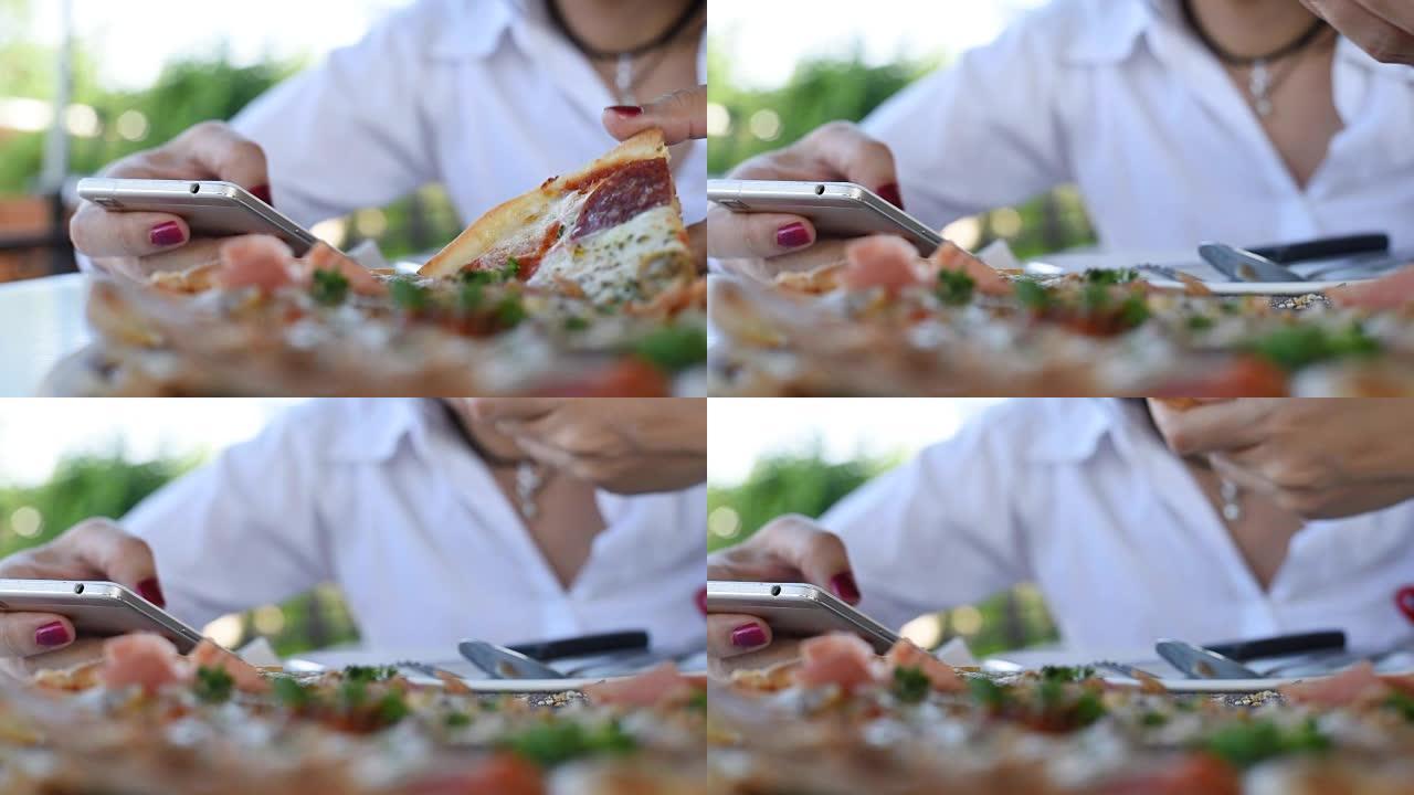 女人用手机吃披萨智能手机打字通话购物披萨