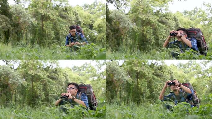 观鸟。兴奋的年轻人观鸟者在雨林背景中使用binolcular。泰国清迈。
