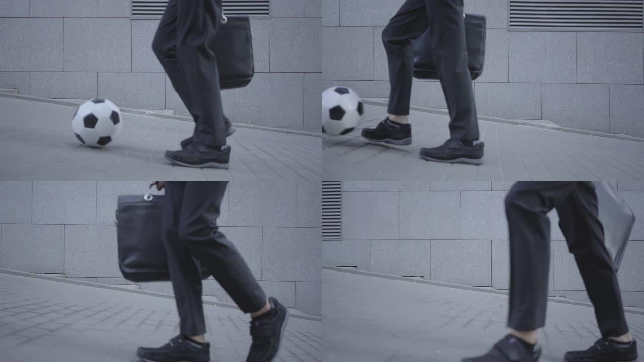 穿着考究的男孩的脚走在街上，领着球，拿着钱包。